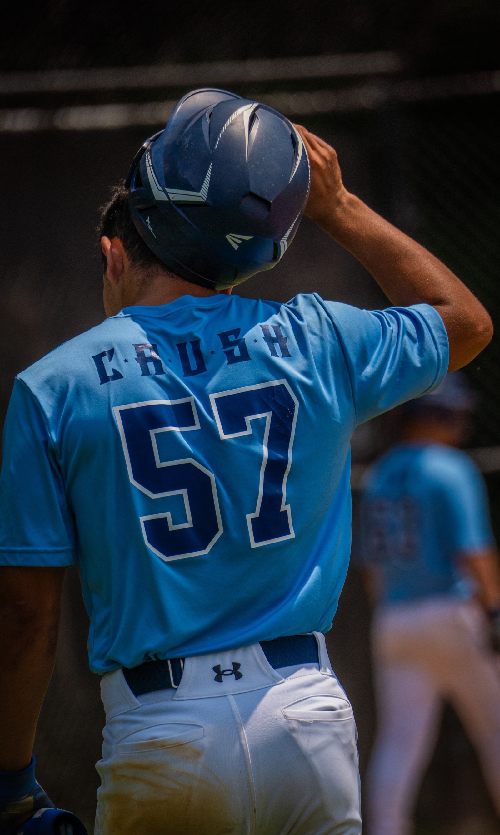 Baseball player lifting his helmet between plays