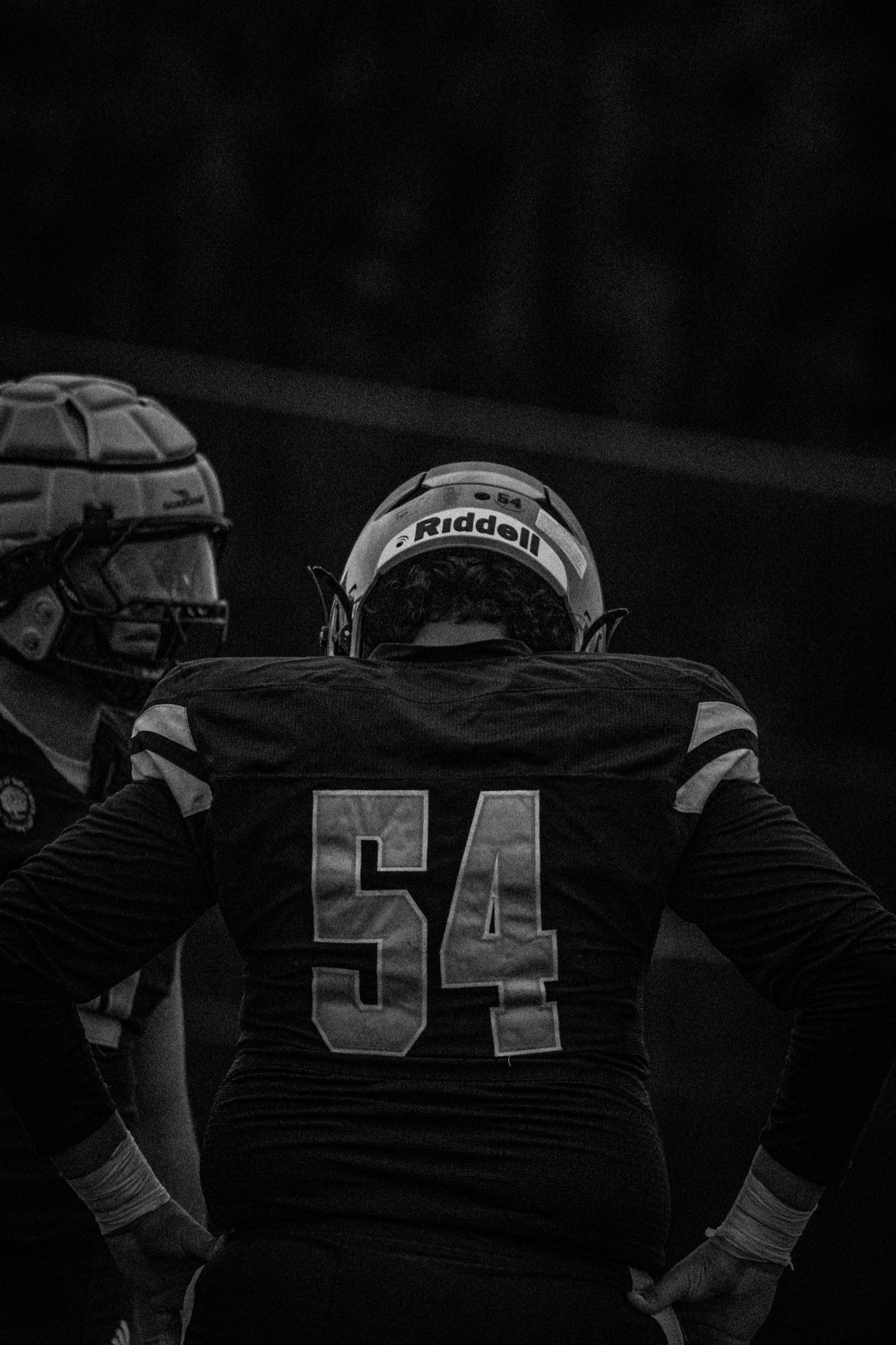 Black and white portrait of a football player wearing number 54