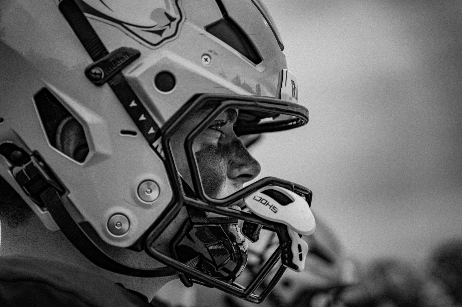 Black and white profile of a football player in a helmet
