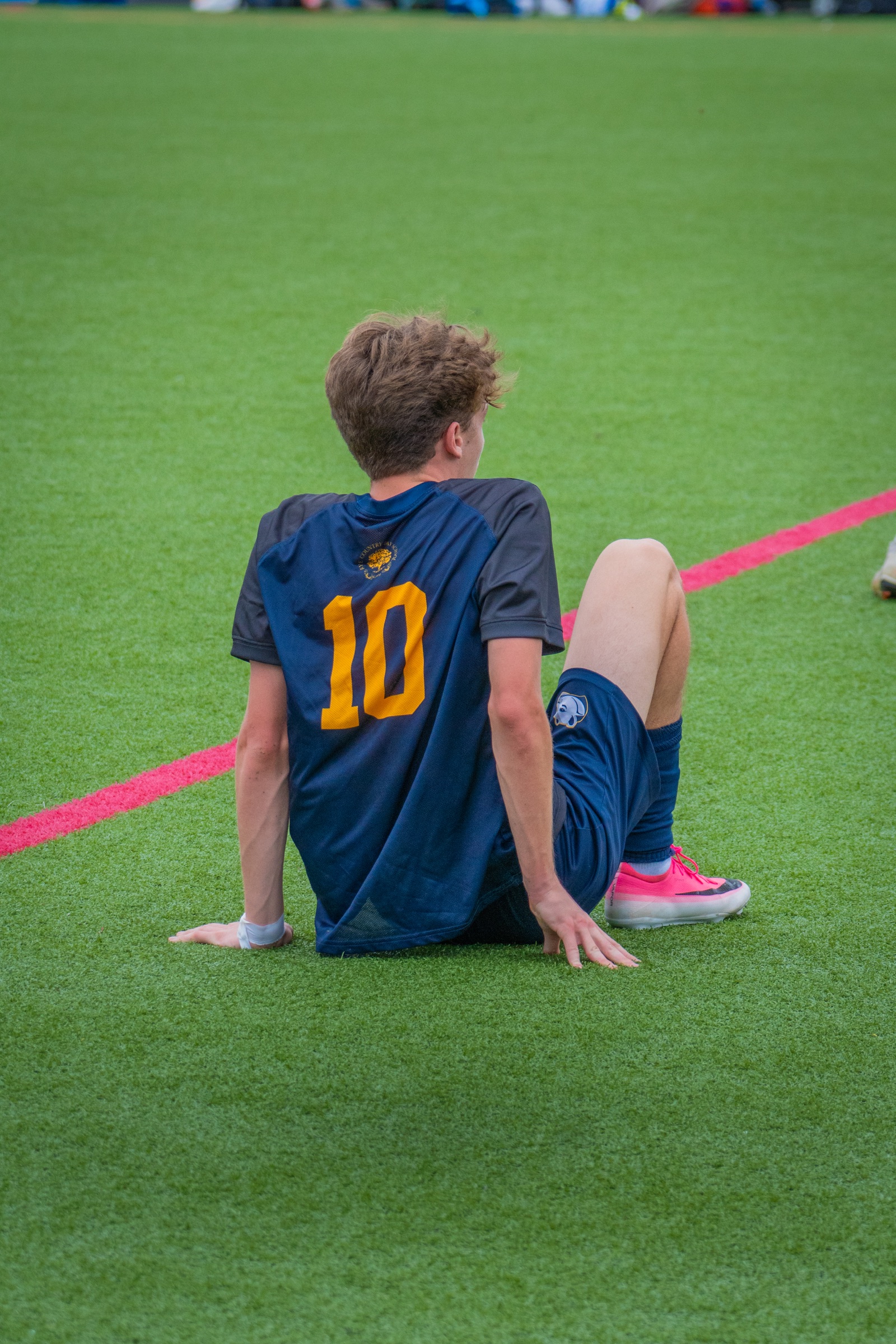 Soccer player sitting on the turf after play